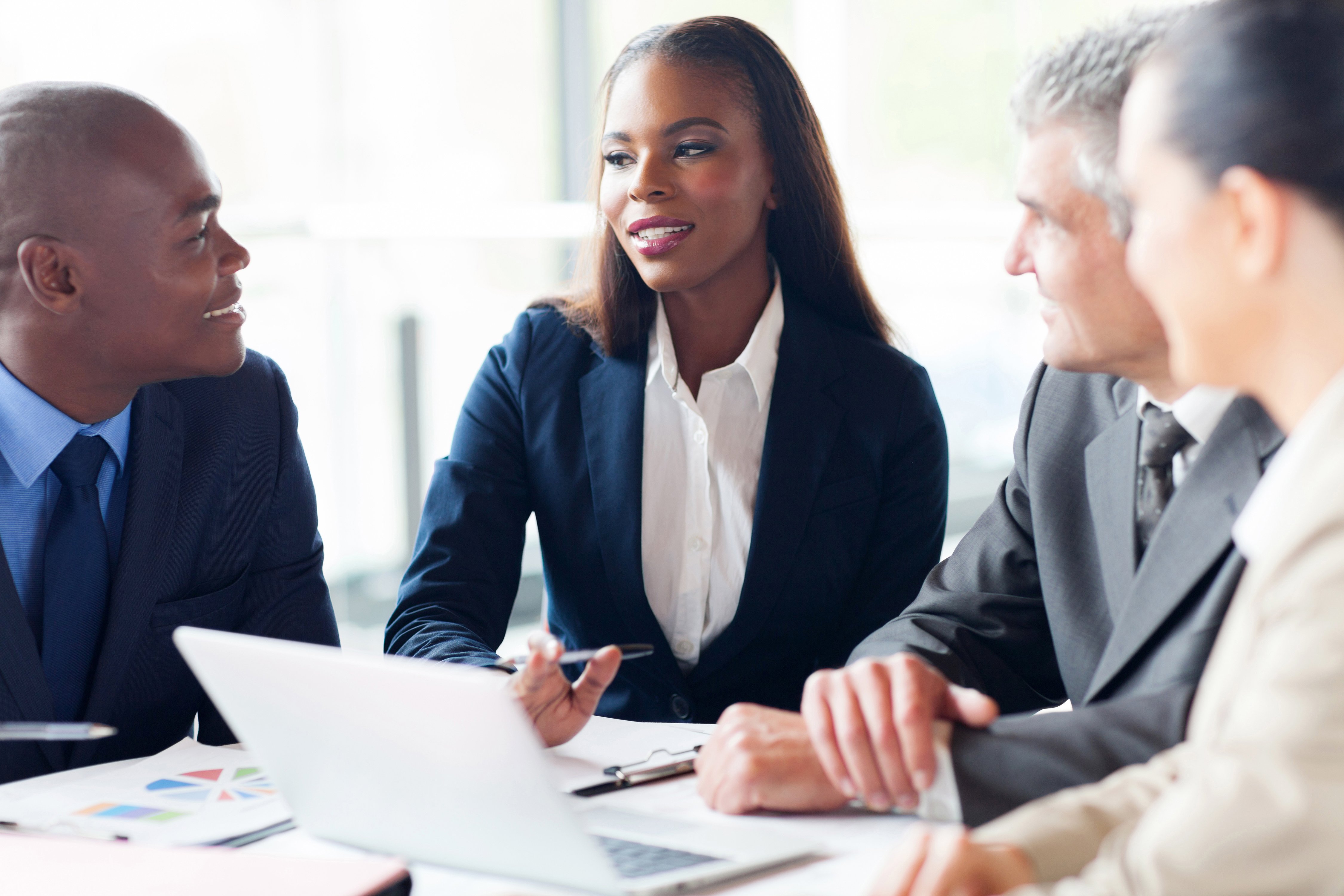 AdobeStock_57354389__Business woman speaking to other business people